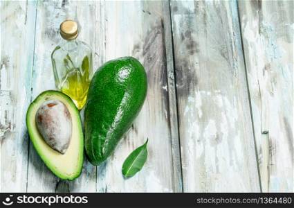 Avocado oil and avocado slices. On a white wooden background.. Avocado oil and avocado slices.