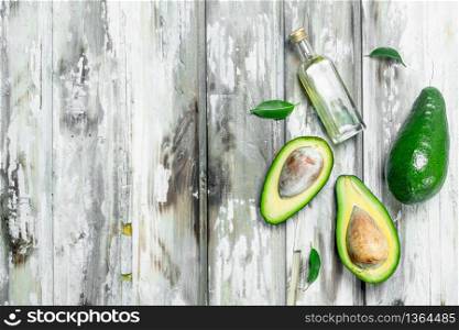 Avocado oil and avocado slices. On a white wooden background.. Avocado oil and avocado slices.