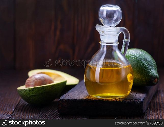 avocado oil in glass and on a table