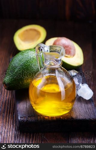 avocado oil in glass and on a table