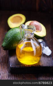 avocado oil in glass and on a table