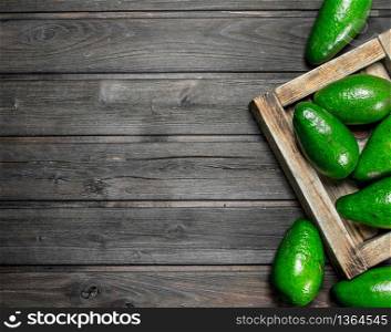 Avocado on a wooden dressing. On a black wooden background.. Avocado on a wooden dressing.