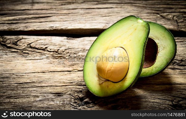 Avocado on the wooden table. Free text space. Avocado on wooden table.