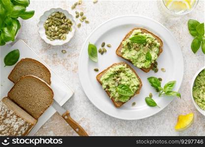 Avocado sandwich with pumpkin seeds. Healthy vegetarian avocado toast with rye bread for breakfast. Vegan menu. Top view