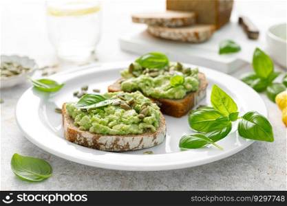 Avocado sandwich with pumpkin seeds. Healthy vegetarian avocado toast with rye bread for breakfast. Vegan menu