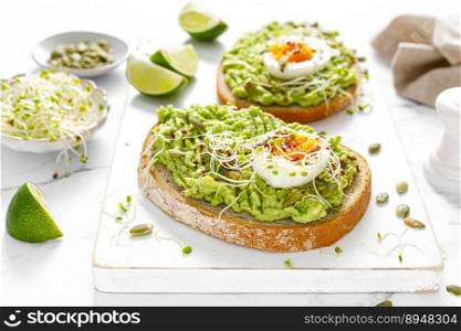 Avocado toast with boiled egg, seeds and sprouts on white background. Healthy diet food