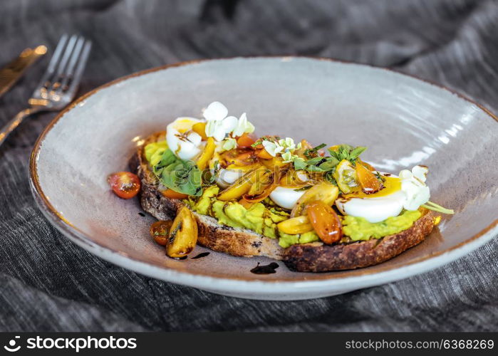 Avocado toast with cherry tomatoes and eggs