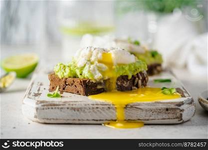Avocado toast with poached egg on white background. Healthy Breakfast concept.. Avocado toast with poached egg