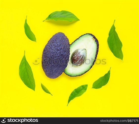 Avocado with leaves on yellow background. Top view