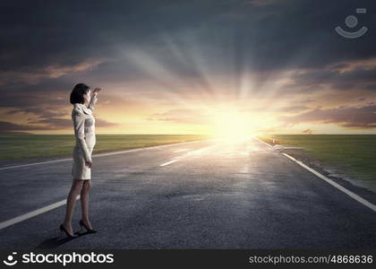 Awaiting for new day. Young businesswoman looking forward on sunrise at horison