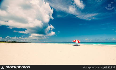 Awesome beach of Varadero during a sunny day, fine white sand and turquoise and green Caribbean sea,on the right one red parasol,Cuba.concept photo,copy space,vintage style.