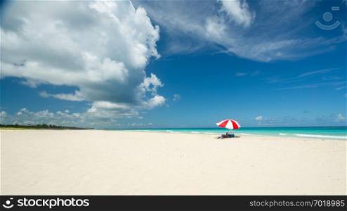 Awesome beach of Varadero during a sunny day, fine white sand and turquoise and green Caribbean sea,on the right one red parasol,Cuba.concept  photo,copy space.
