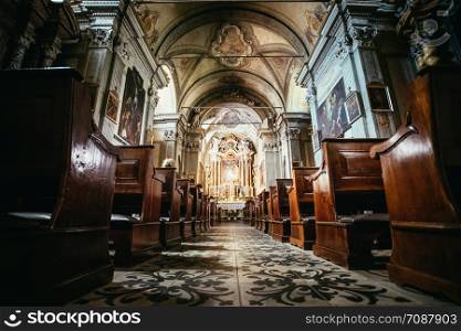 Awestruck catholic church in Italy with antique wooden pews and a beautiful altar