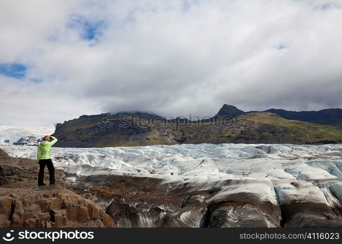 Awoman hiker looking out on the Vatnajokull Glacier, Iceland