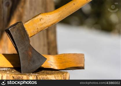 Ax stuck in block of wood winter