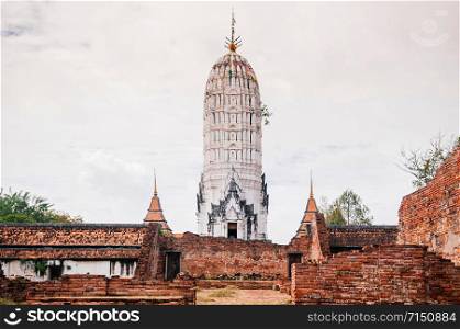 Ayutthaya ancient Buddhist pagoda among ruined brick wall of Wat Putthaisawan historic Temple - Thailand.