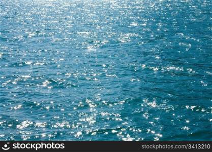 Azure sea water surface with ripple and sun reflection sparkles