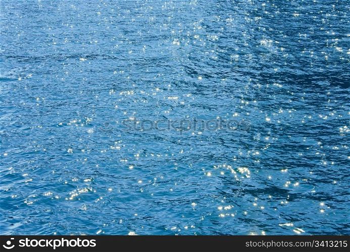 Azure sea water surface with ripple and sun reflections