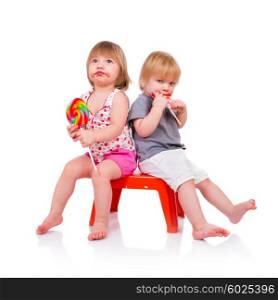 Babies eating a sticky lollipop on white background