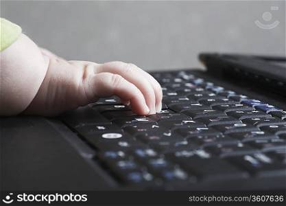 Baby&acute;s hand on computer keyboard