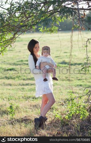 baby and mother strolling on suburban landscape