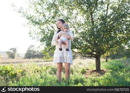 baby and mother strolling on suburban landscape
