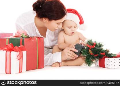baby and mother with christmas gifts over white (focus on baby)