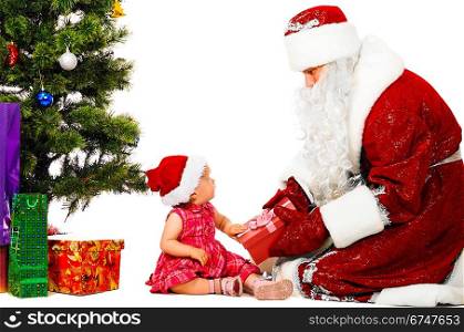 baby and santa claus near christmas tree with gifts
