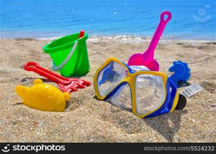 Baby beach toys on the sand against the blue sea