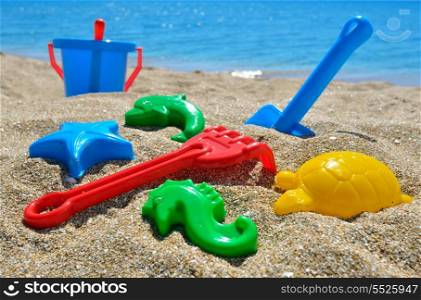 Baby beach toys on the sand against the blue sea