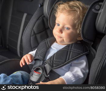 Baby boy 8 months old in a safety car seat.