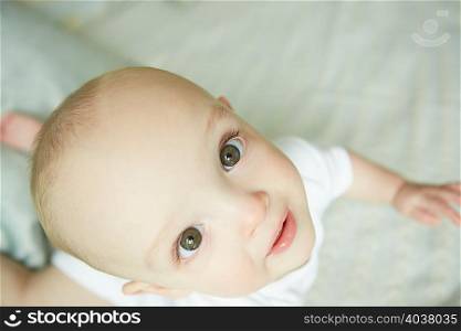 Baby boy crawling on bed