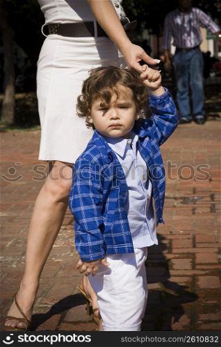 Baby boy holding his mother&acute;s finger and walking