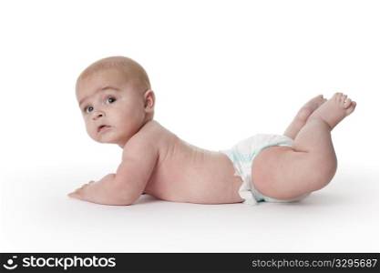 Baby boy lying on his belly full lenght on white background