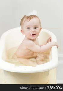 Baby boy playing in foam while having bath