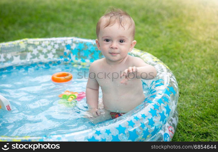 Baby boy playing in swimming pool at garden