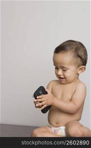 Baby boy playing with a mobile phone