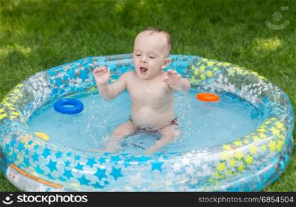 Baby boy playing with toys in swimming pool at garden