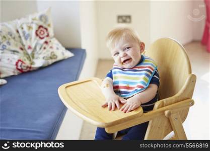 Baby Boy Sitting In High Chair