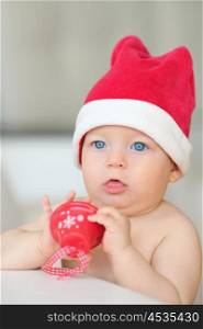 Baby boy with blue eyes christmas portrait in Santa Claus hat