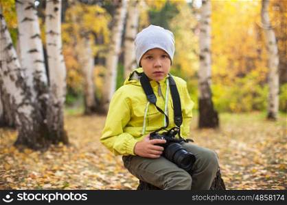 Baby boy with camera. Baby boy with camera in autumn forest
