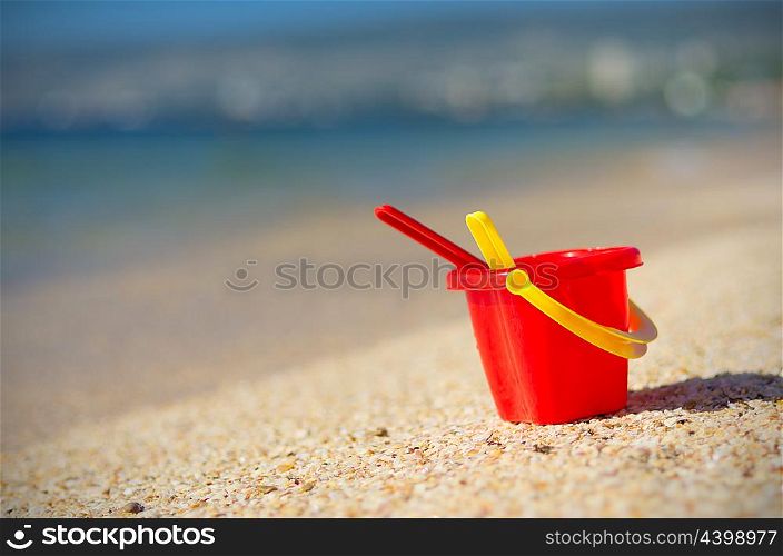 Baby bucket on sand at sea coast