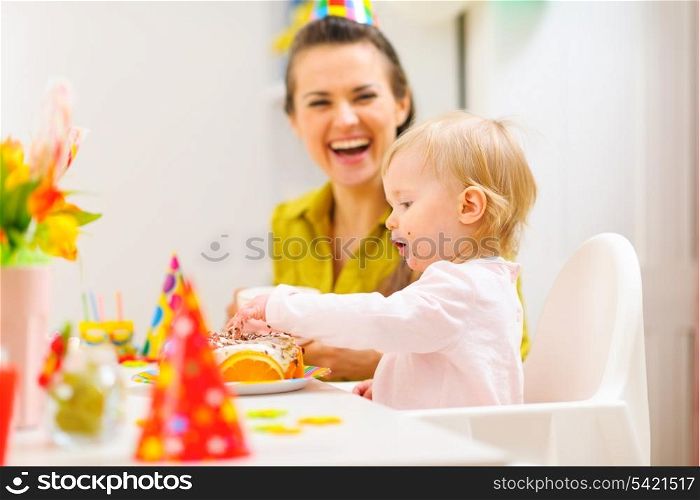 Baby celebrating first birthday with mother