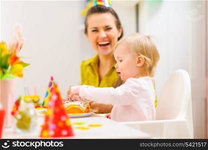 Baby celebrating first birthday with mother