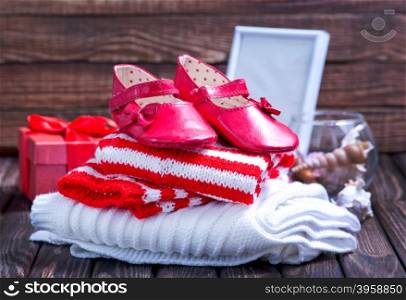 baby clothes and shoes on the wooden table