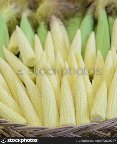 Baby corn cobs in woven basket