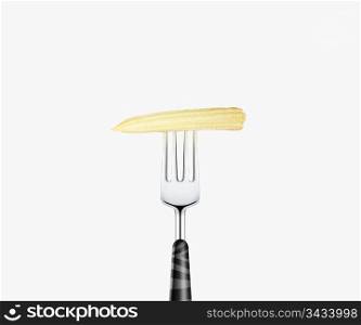 baby corn pierced by fork, isolated on white background