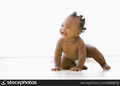 Baby crawling indoors smiling