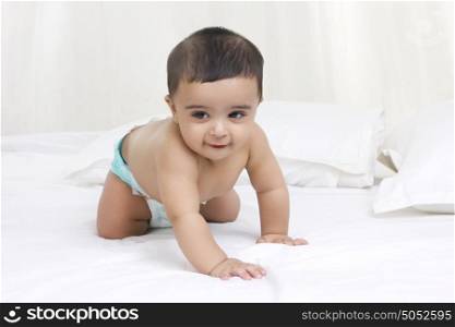 Baby crawling on bed