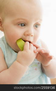 Baby eating apple indoors